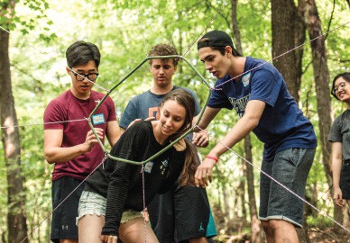 Teens make their way through a team-building obstacle course